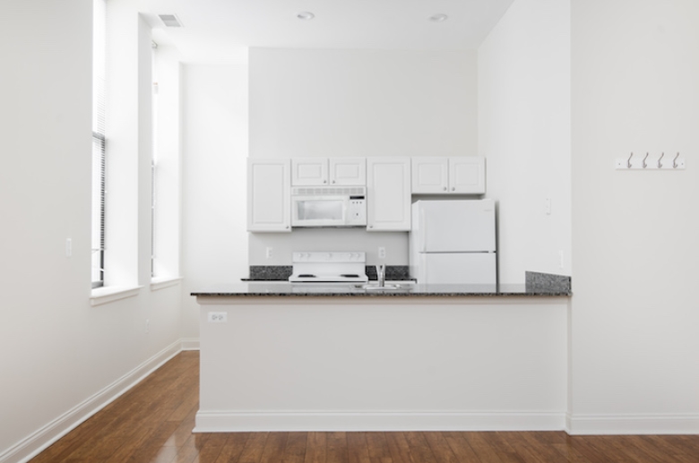 Victory Building Apartments kitchen featuring wooden floor