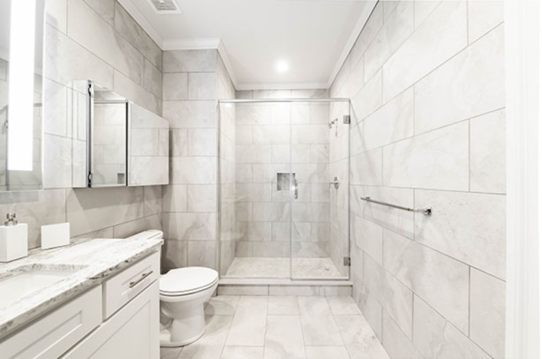 Spa-style tiled bath with seamless shower doors at 1420 Chestnut Street