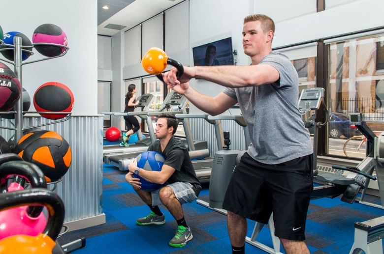 Residents enjoying free weights and cardio equipment 