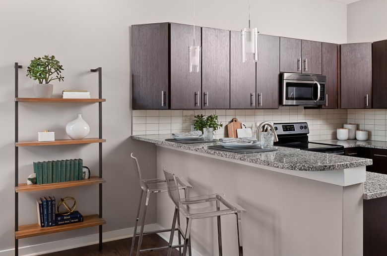 Fully-equipped kitchen with granite countertop, le backsplash, and stainless steel appliances