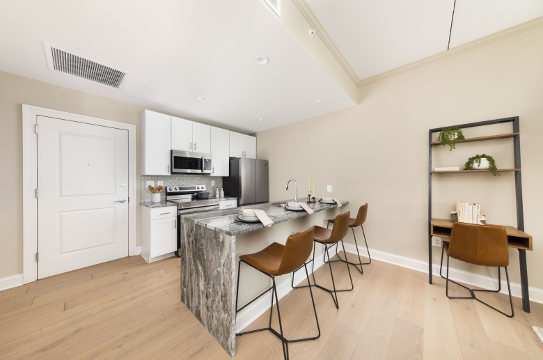 Kitchens feature hardwood flooring and waterfall countertops