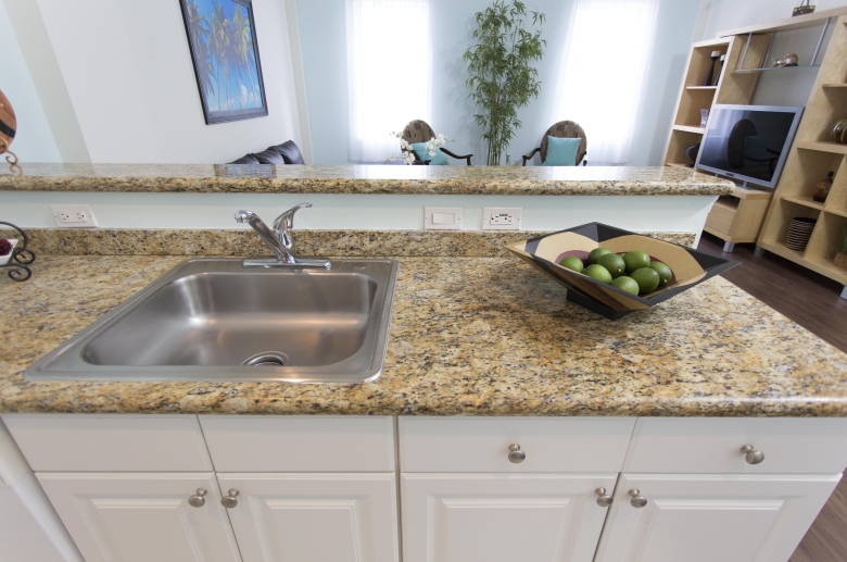 Breakfast bar features granite counter top and stainless steel under-mounted sinks