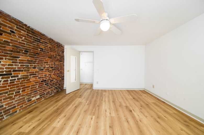 Bedroom featuring hardwood and exposed brick walls 