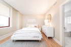 Furnished sample bedroom in a 2-BR unit at 1420 Chestnut