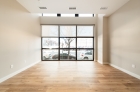 A full-length wall of living room windows overlooking Market Street in Philadelphia