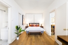 Furnished bedroom featuring hardwood flooring